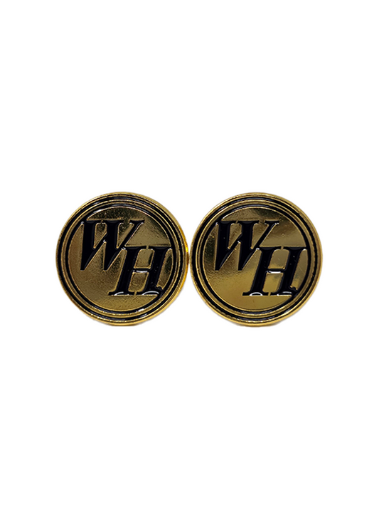 Stud earrings are circular gold-toned discs featuring the bold, black interlaced letters "WH" encircled by a thin black border, finished with smooth metallic surfaces and standard silver-toned posts.